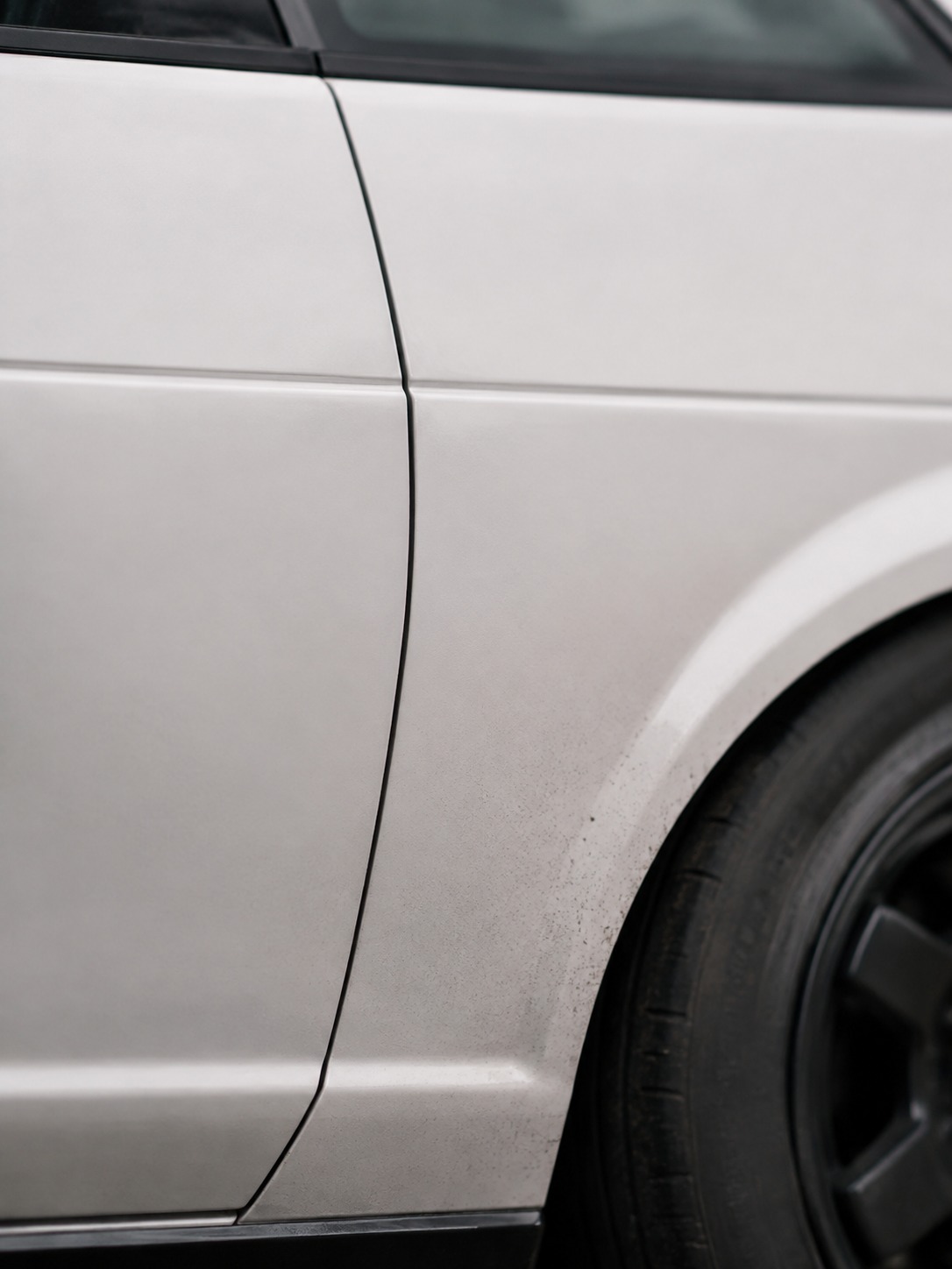 Toyota AE86 flat door character line detail A close detail of a Toyota AE86 door panel and wheel arch showing the flat character line and subtle brake dust. | Sky Rye Design A close detail of a Toyota AE86 door panel and wheel arch showing the flat character line and subtle brake dust.