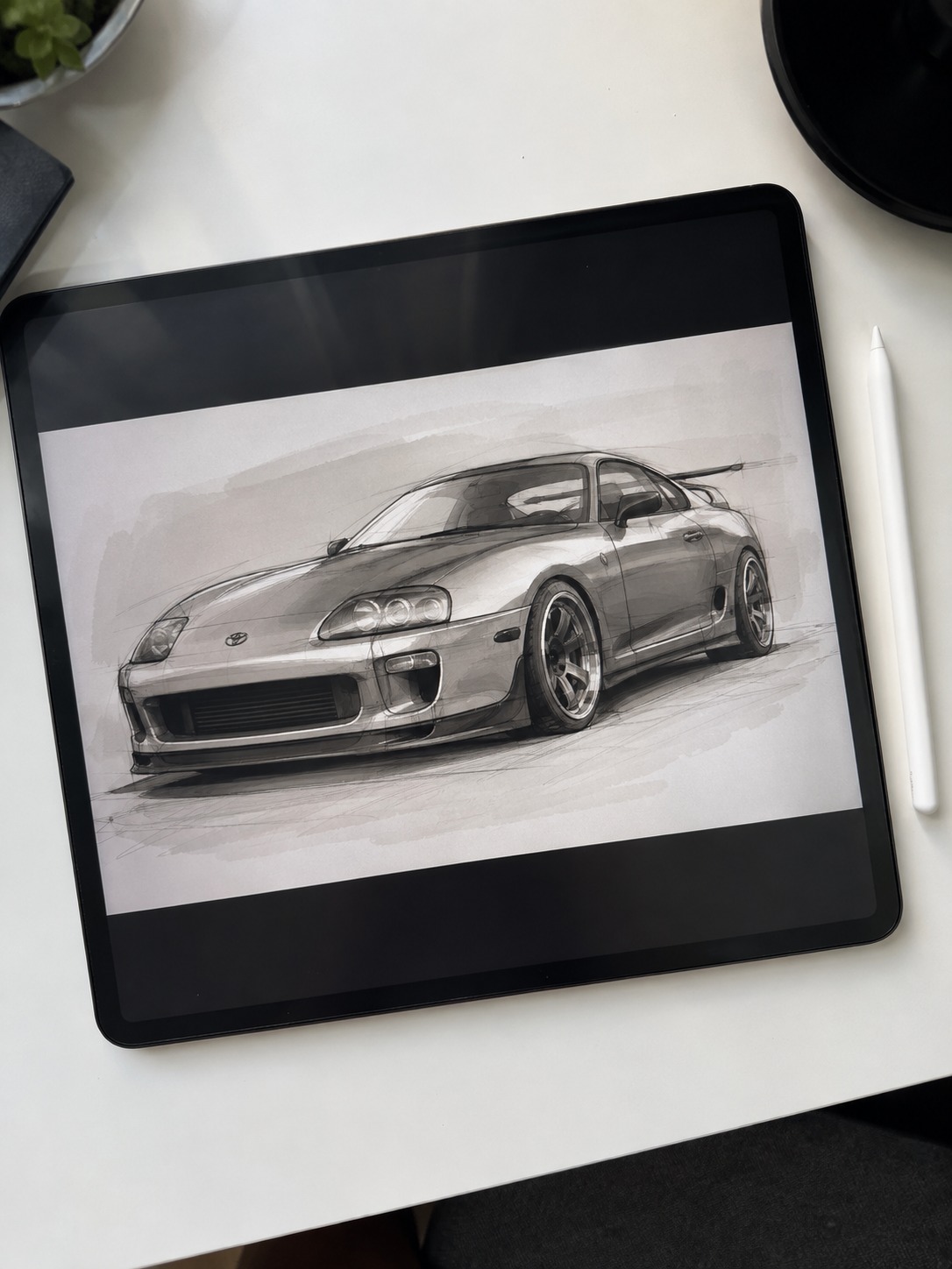 Toyota Supra sketch on a digital drawing tablet A digital drawing tablet on a white desk displaying a Toyota Supra sketch in progress. | Sky Rye Design A digital drawing tablet on a white desk displaying a Toyota Supra sketch in progress.