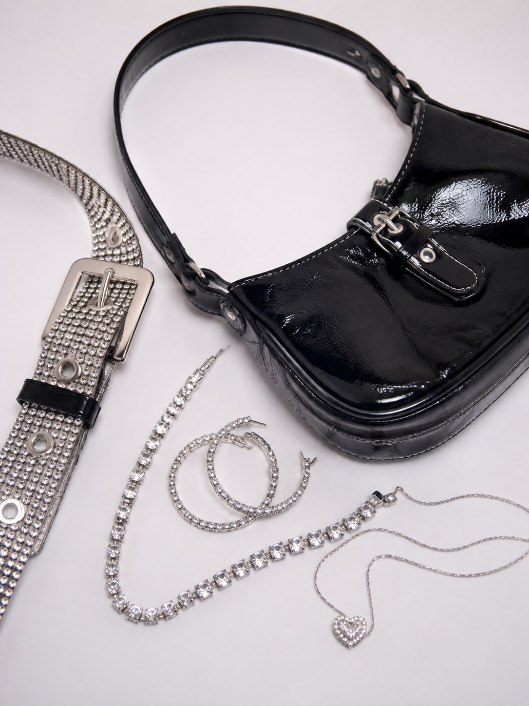 Glam accessories moodboard Rhinestone belt, glossy shoulder bag and sparkling jewelry in a glam flat lay | Sky Rye Design Rhinestone belt, glossy shoulder bag and sparkling jewelry in a glam flat lay