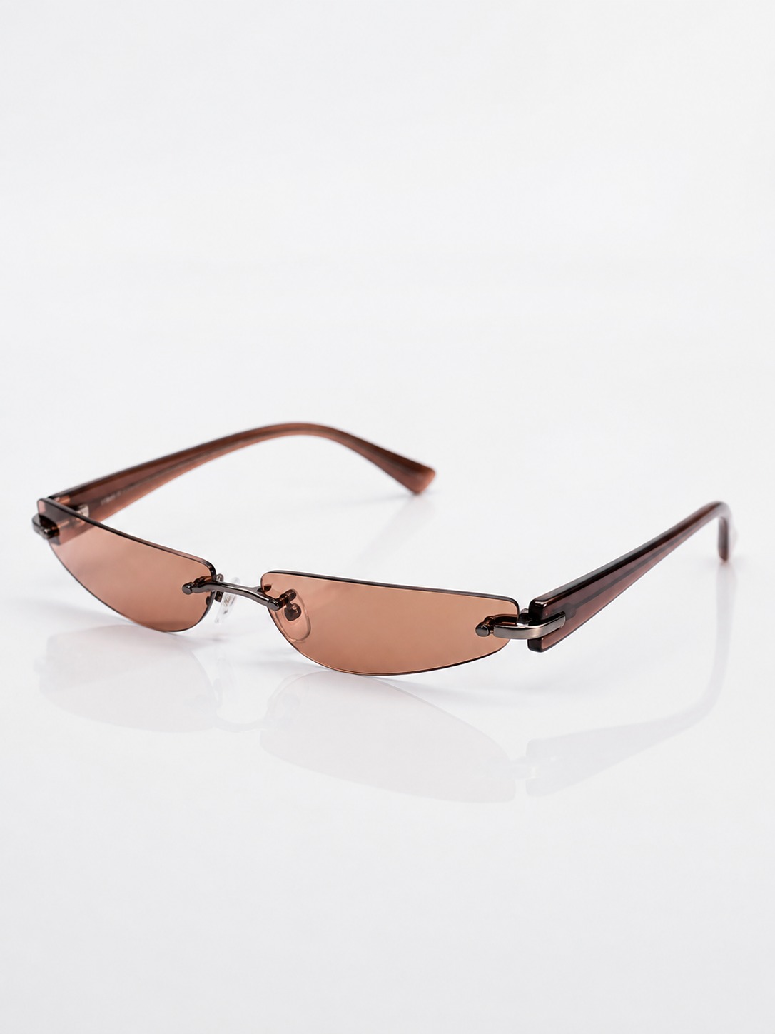 Rimless tinted sunglasses Rimless sunglasses with narrow tinted lenses on a glossy white surface | Sky Rye Design Rimless sunglasses with narrow tinted lenses on a glossy white surface