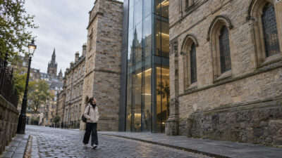 Visitor looking up at old and new buildings during an architectural walking tour