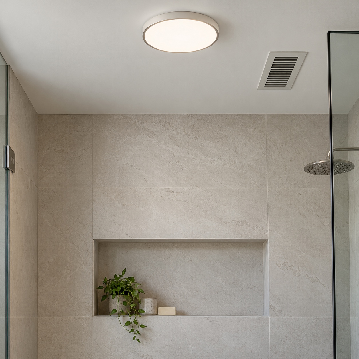 Bathroom ceiling with a flush light and slim exhaust grille above a shower niche