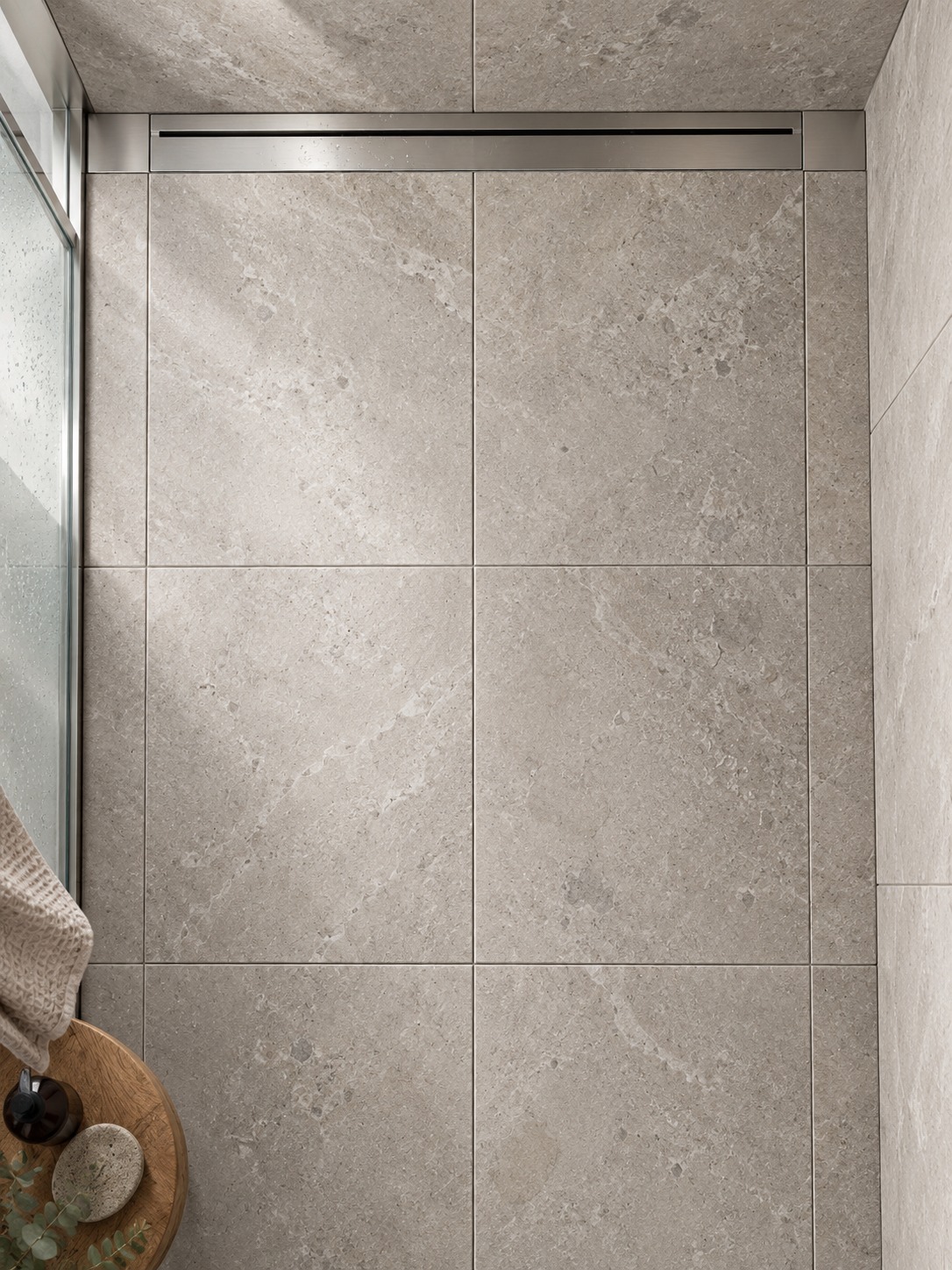 Square floor tiles with balanced cuts beside a linear drain