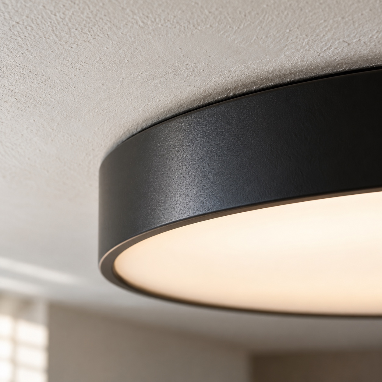 Black flush mount light finish and diffuser detail Close view of a satin black light rim, plaster texture and softly glowing opal diffuser. | Sky Rye Design Close view of a satin black light rim, plaster texture and softly glowing opal diffuser.