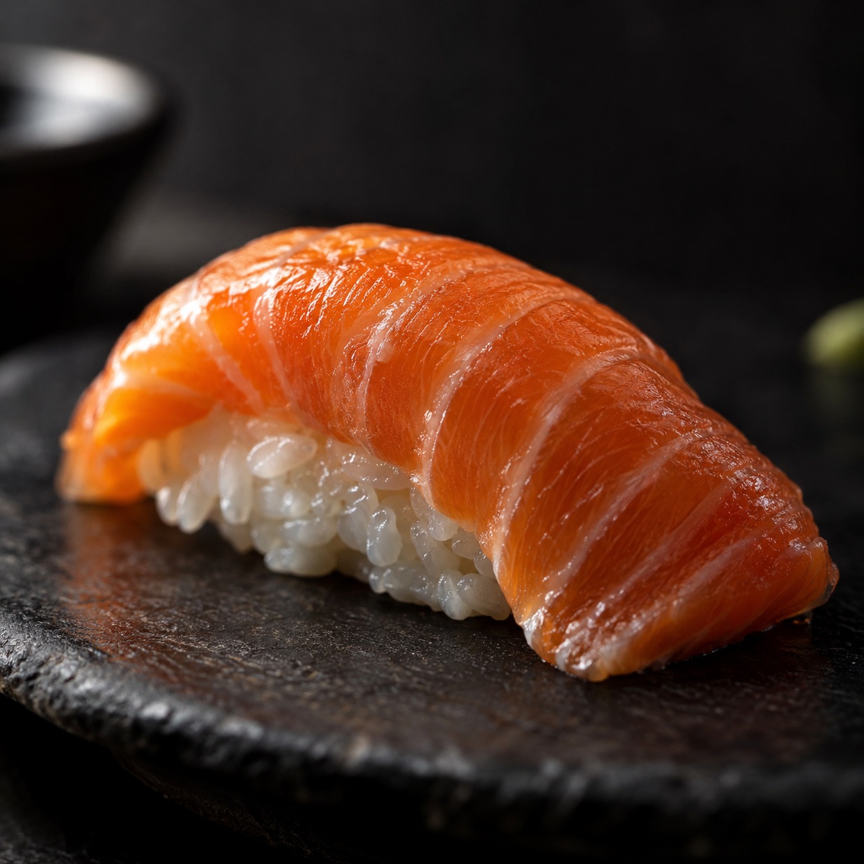 Macro view of salmon nigiri with one thin highlight and soft reflected light
