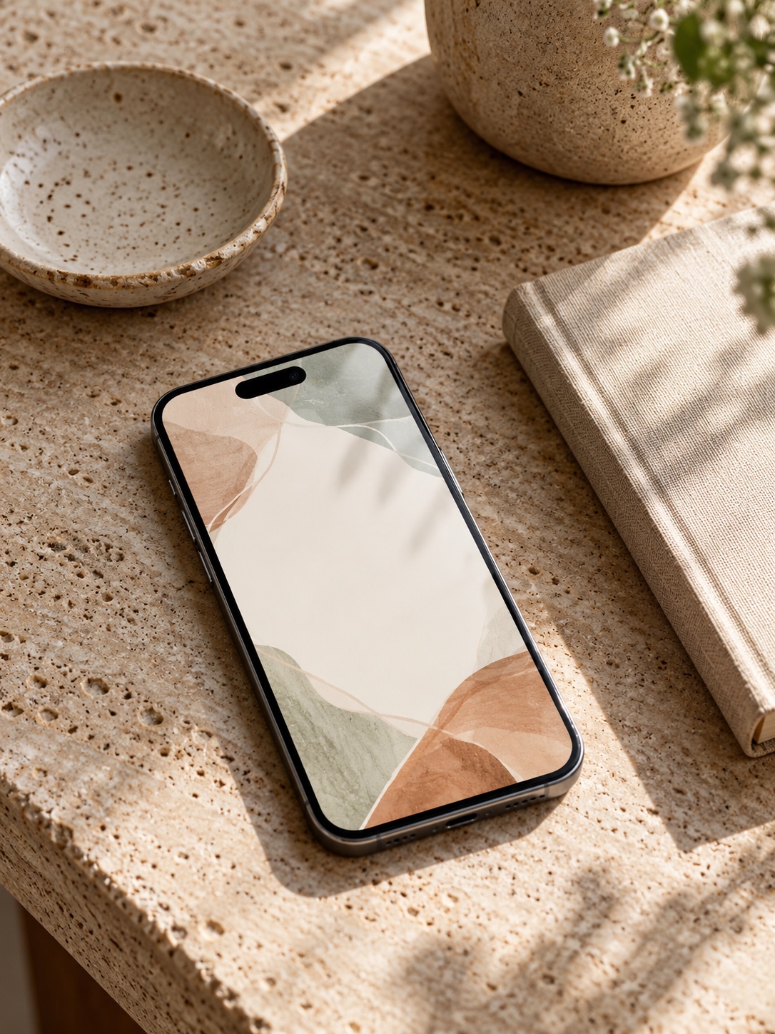 A phone on a travertine desk showing a soft-toned abstract wallpaper with a single short line of text area left blank a small notebook beside it A phone on a travertine desk showing a soft-toned abstract wallpaper with a single short line of text area left blank, a small notebook beside it | Sky Rye Design A phone on a travertine desk showing a soft-toned abstract wallpaper with a single short line of text area left blank, a small notebook beside it