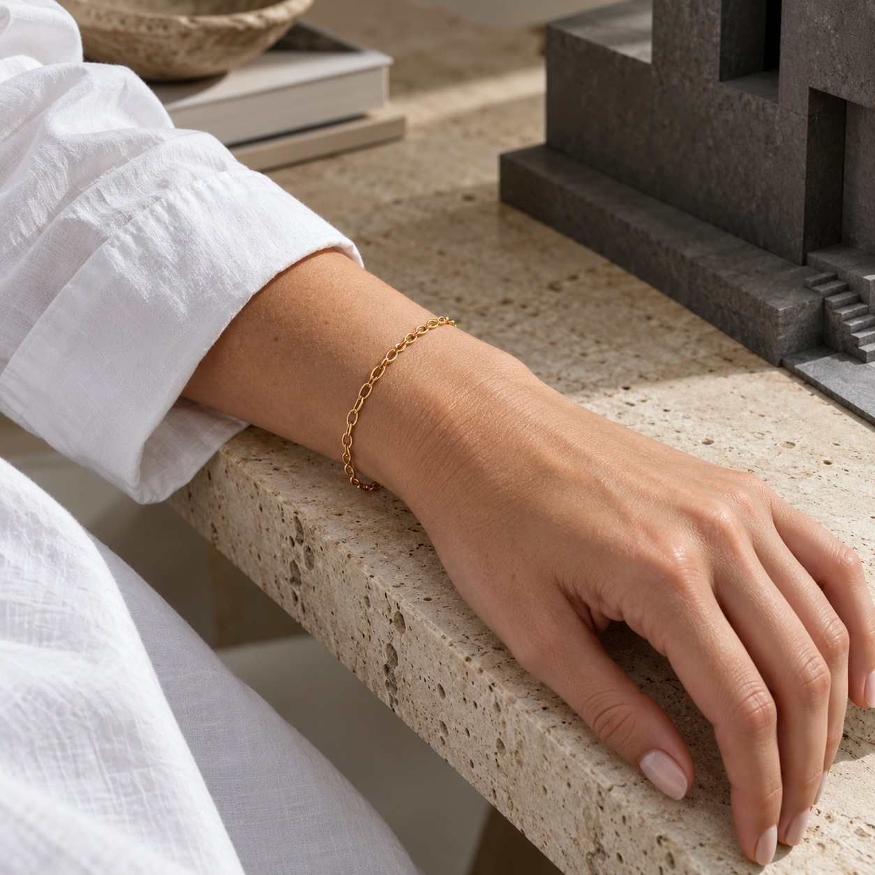 Single gold-plated bracelet with negative space Close view of a single delicate gold-plated bracelet framed by a rolled white shirt sleeve and bare wrist. | Sky Rye Design Close view of a single delicate gold-plated bracelet framed by a rolled white shirt sleeve and bare wrist.