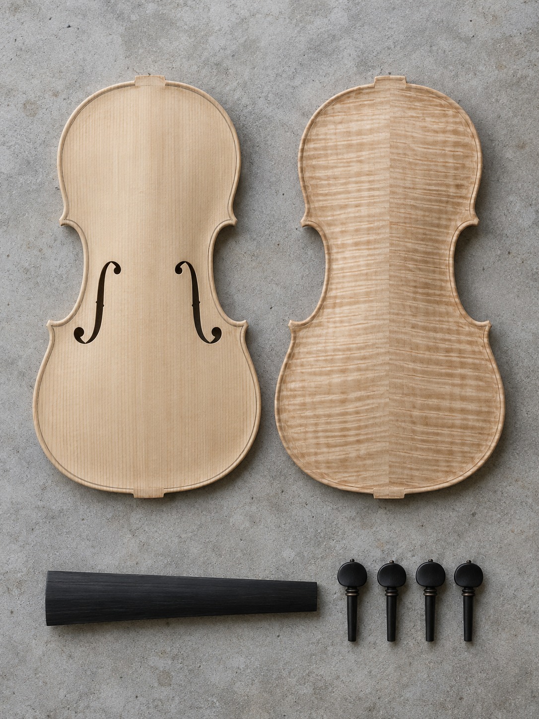 Materials used in a violin Spruce top, figured maple back, ebony fingerboard and four pegs on pale concrete | Sky Rye Design Spruce top, figured maple back, ebony fingerboard and four pegs on pale concrete